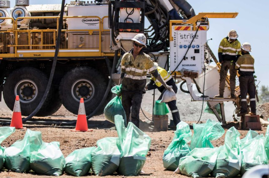 man carrying green UV plastic bags in a drill site