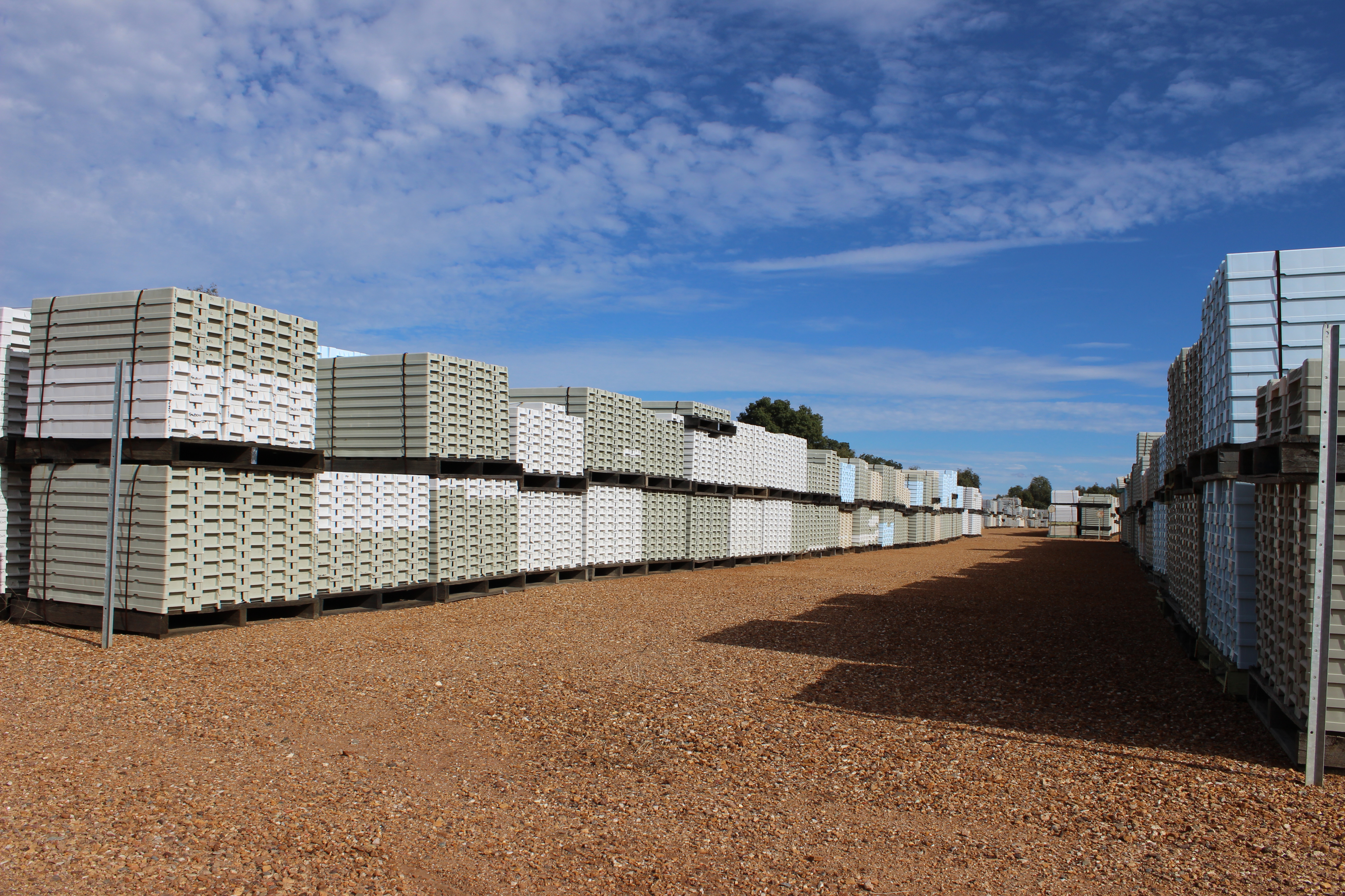 Stacks of plastic core trays under the heat of the sun