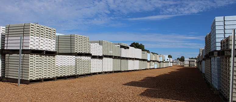 Stacks of plastic core trays under the heat of the sun